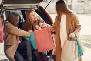 Happy friends sharing impressions after shopping paper bags