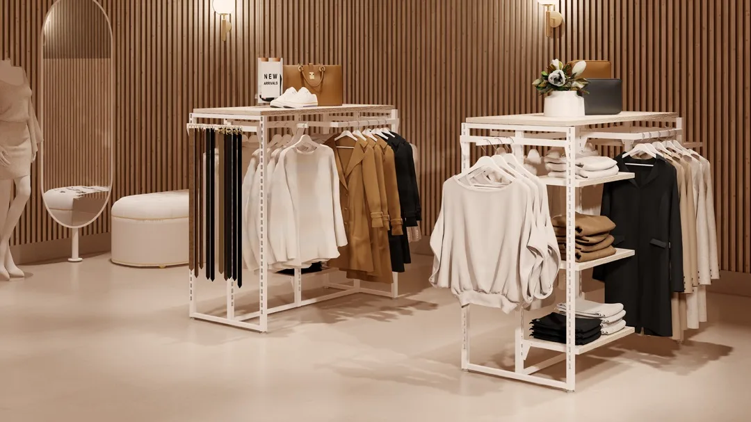A boutique clothing store features a pristine retail display with white metal racks showcasing neatly organized jackets, sweaters, and folded clothes. A mirror and a white circular ottoman sit against a wooden panel wall, enhanced by soft lighting for an inviting shopping experience.