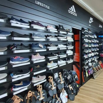Black slatwall display sports shoes in a retail store
